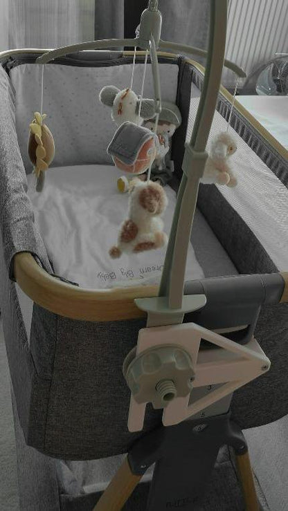 Musical mobile adapter attached on the  Tutti bambini Cozee bedside crib co sleeper with mama and papas musical mobile soothervertical view full crib image