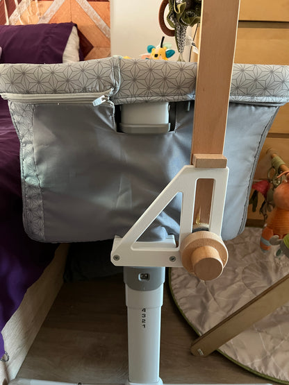 Closeup of CribClamp baby mobile adapter securely attached to a Chicco Next2Me Dream bedside crib, holding a Little Dutch wooden musical mobile arm.